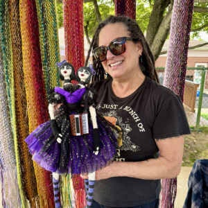 Artist Ginny Loving shows off fiber arts on sale from her booth.