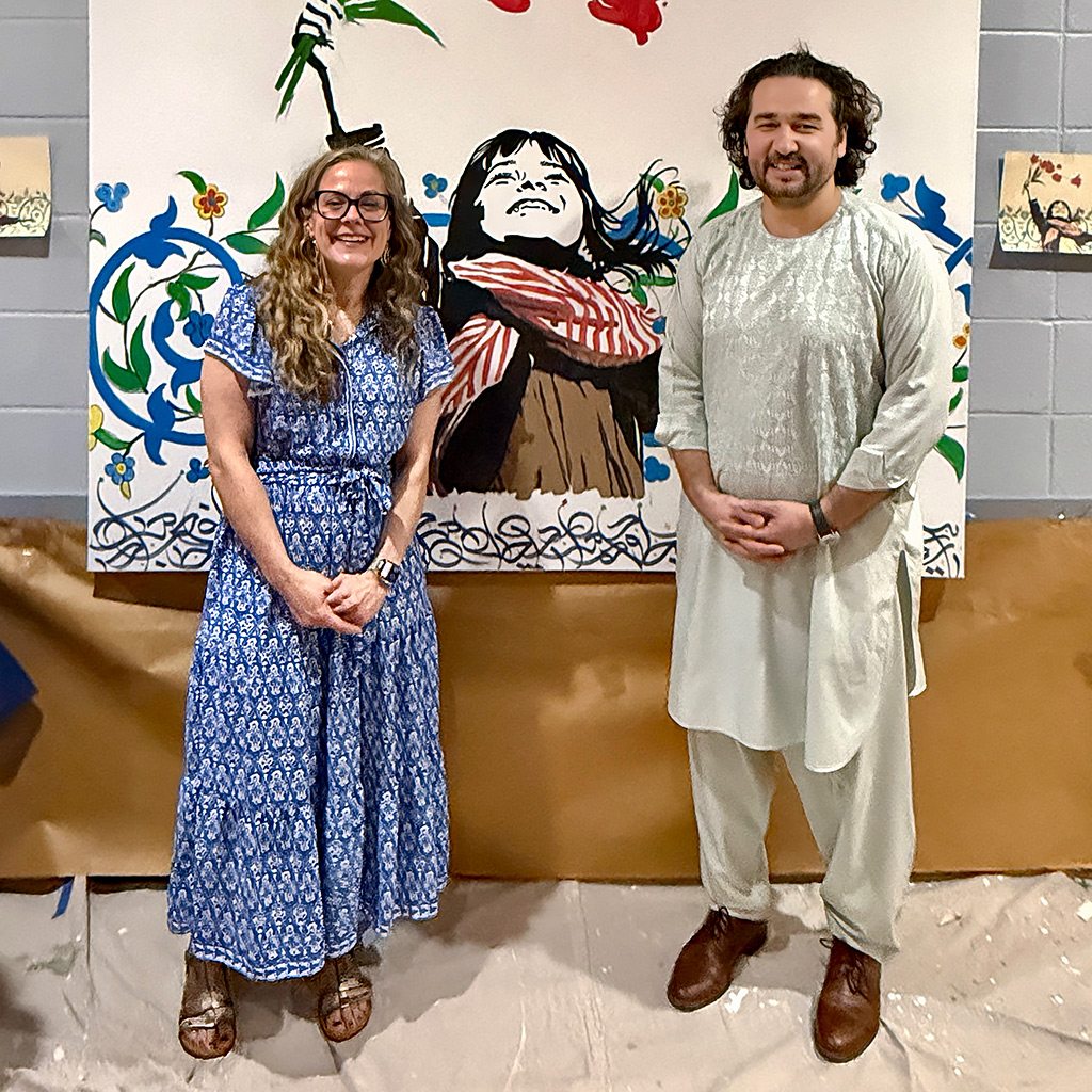Rev. Casey Wait with Omaid Sharifi, who co-founded the art collective Art Lords, pose with the community mural painted during the Nowruz celebration on March 21, 2026 at John Calvin Presbyterian Church in Annandale, VA.