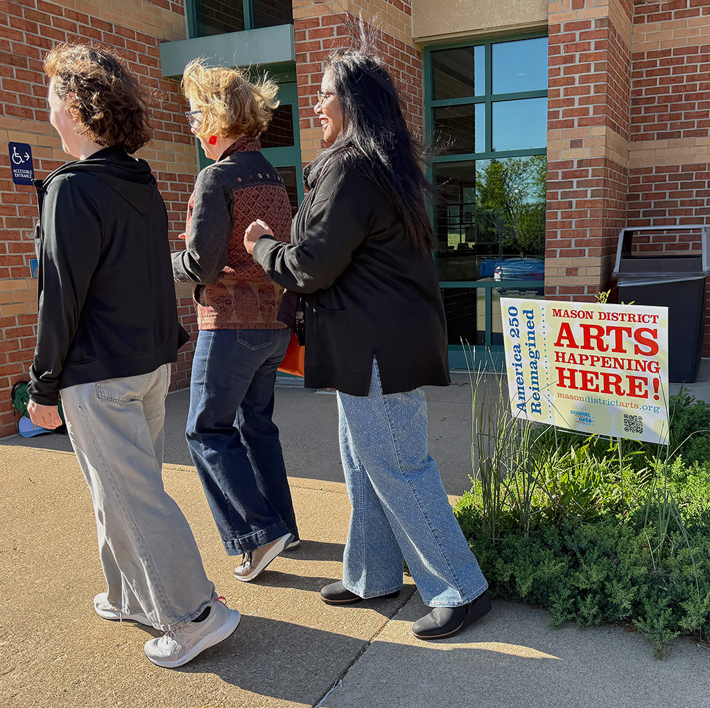 Neighbors walking past Mason Arts 250 event signage in the Mason District Governmental Center in Annandale, VA, on May 1, 2026.