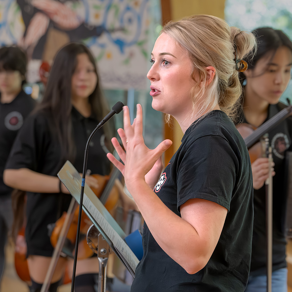 Annie Ray, Orchestra Director and Performing Arts Department Chair at Annandale High School, talks about the importance of community arts during a break between songs.