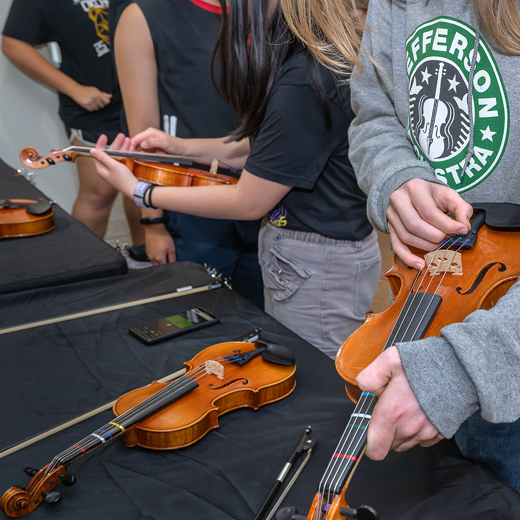 Kids holding string instruments during the "petting zoo."