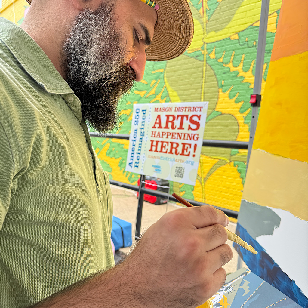 Sulieman Hedayat, from ArtLords, works on the community mural for the Mason District Arts Council as part of the Mason Arts 250 series of activities to commemorate America's 250 founding anniversary.
