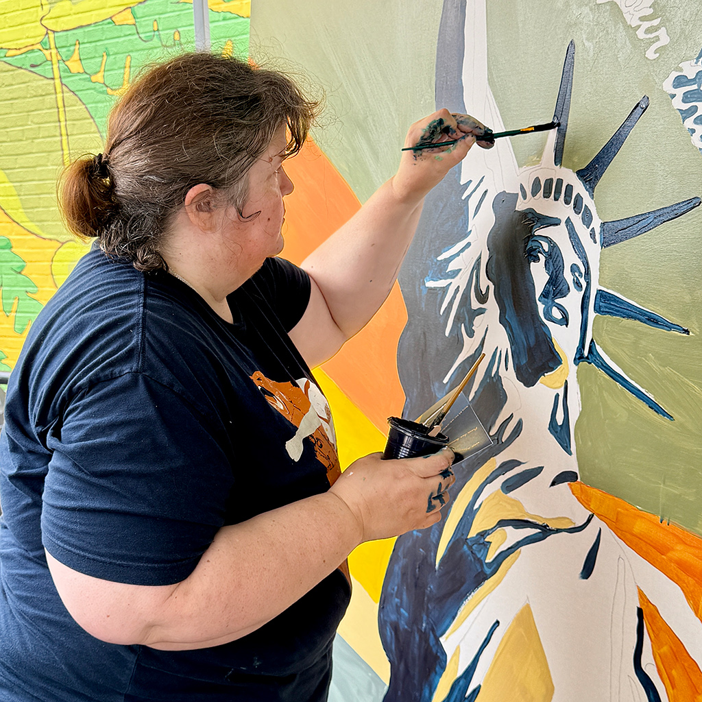 Volunteer painting during Mason District Arts Council community mural project, part of the Mason Arts 250 series of activities to commemorate America's 250 founding anniversary.