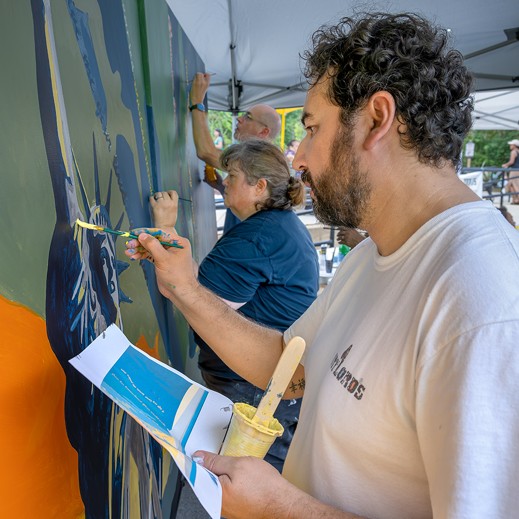 Omaid Sharifi, President of ArtLords, a collective of self-styled "artivists" who create street art worldwide, leads the painting.